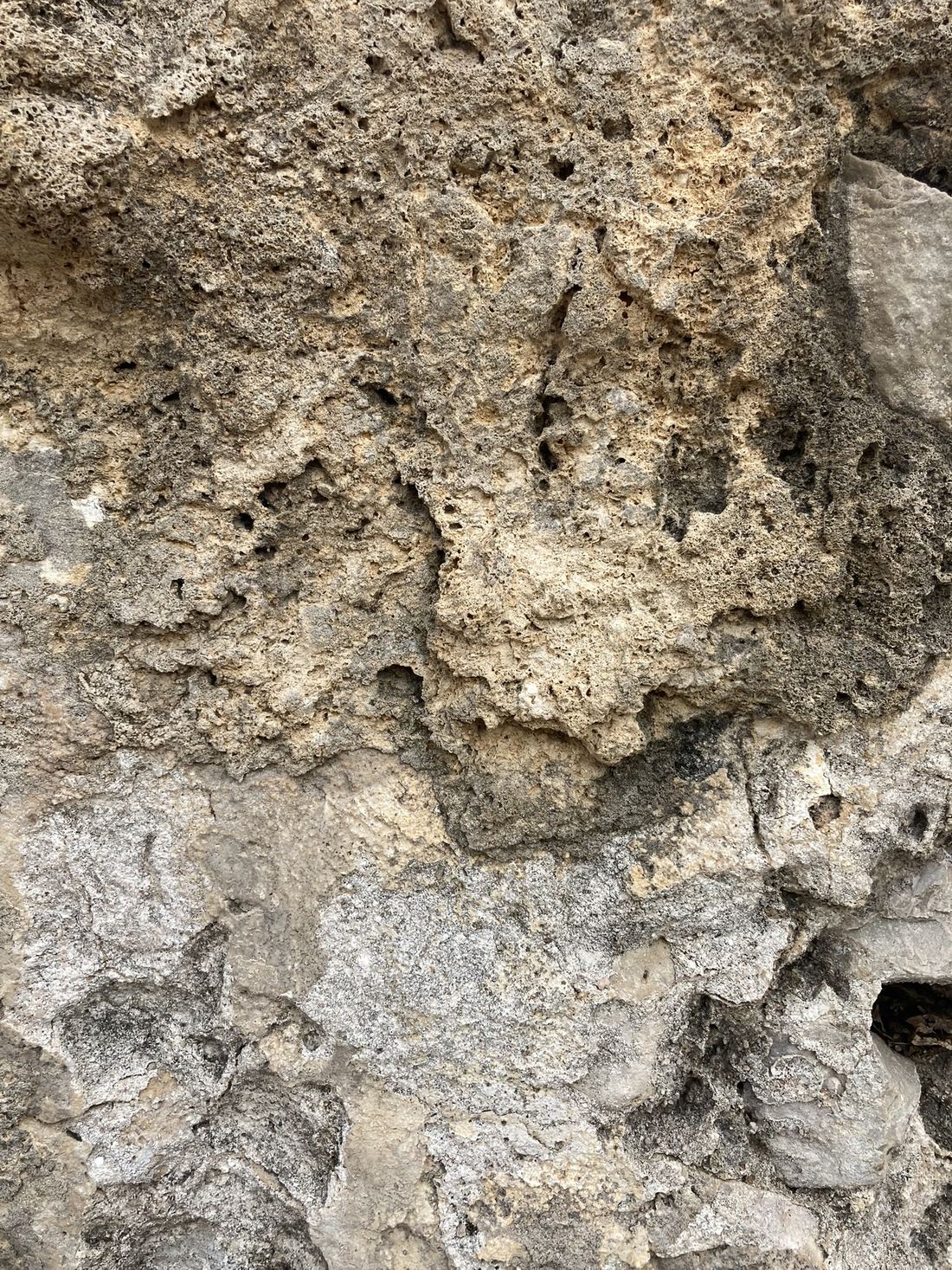 Close-up of rough grey Roman concrete from an aqueduct, packed with small stones and pale lumps of lime