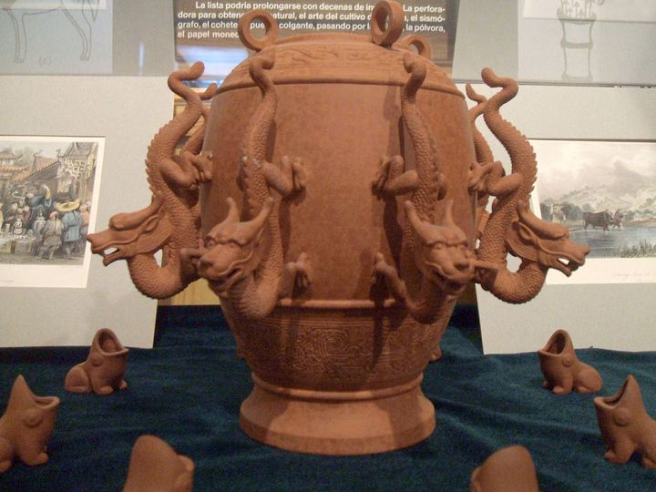 A terracotta-colored replica of Zhang Heng's seismoscope, a large urn with dragon heads around its upper body and open-mouthed toads waiting below